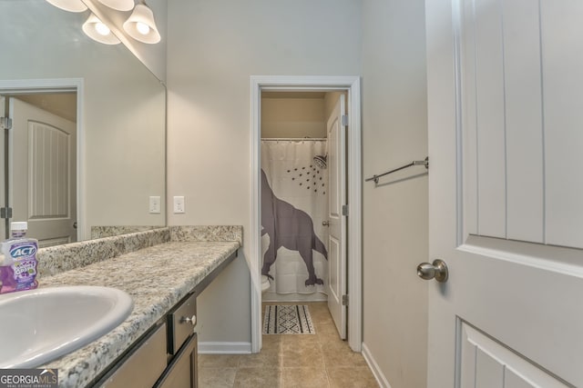 full bathroom with toilet, baseboards, vanity, and tile patterned floors