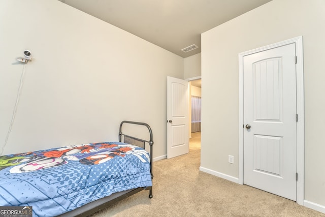 bedroom with visible vents, light carpet, and baseboards