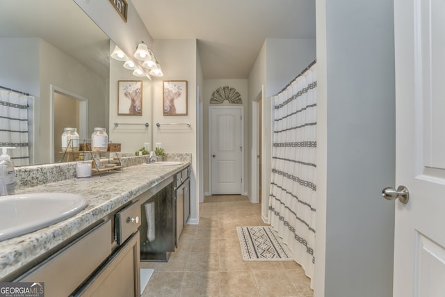 full bathroom featuring double vanity, tile patterned flooring, baseboards, and a sink