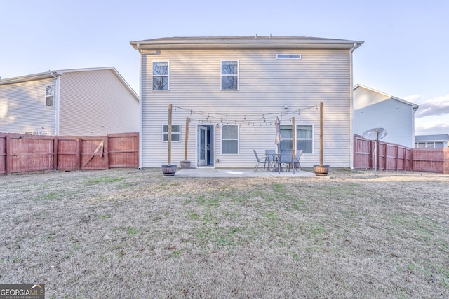 back of house with a lawn, a patio area, and a fenced backyard