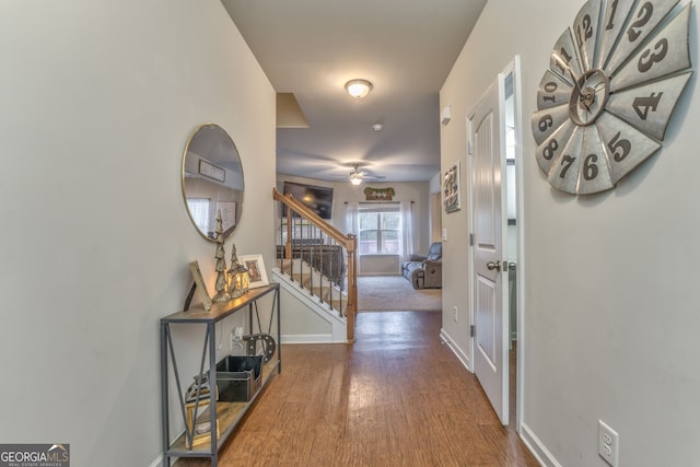 hallway featuring stairs, baseboards, and wood finished floors