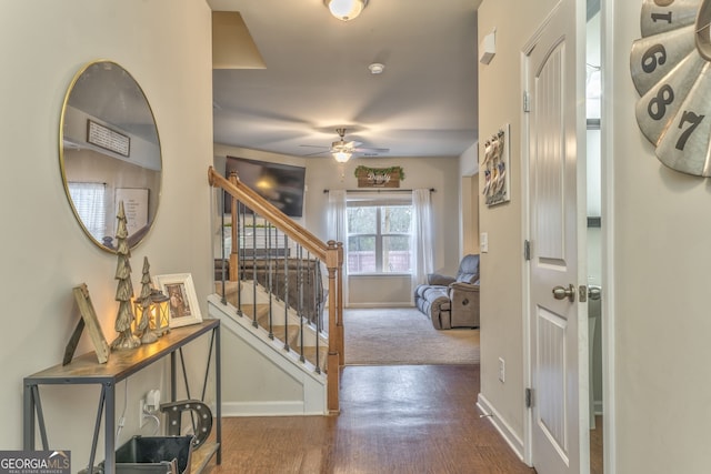 foyer entrance with a ceiling fan, dark wood finished floors, stairway, and baseboards