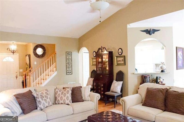 living room with ceiling fan with notable chandelier and lofted ceiling