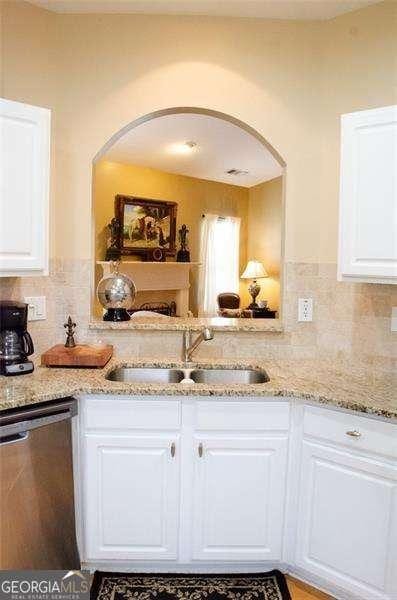 kitchen with white cabinets, stainless steel dishwasher, and sink