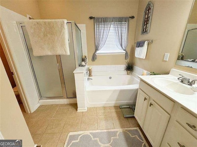 bathroom with tile patterned flooring, vanity, and shower with separate bathtub