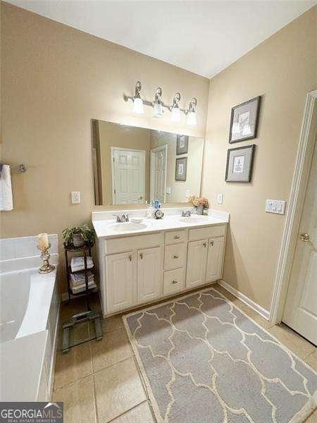 bathroom with vanity, tile patterned floors, and a bathing tub