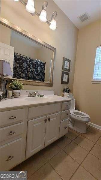 bathroom with tile patterned flooring, vanity, and toilet