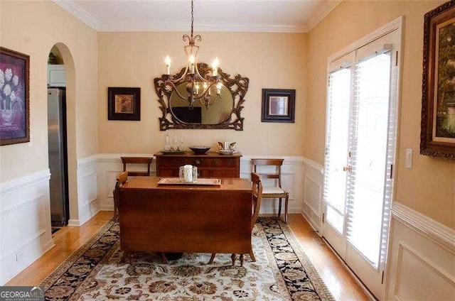 dining area featuring light hardwood / wood-style floors, a notable chandelier, and ornamental molding