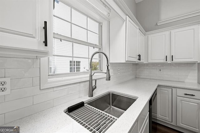 kitchen featuring decorative backsplash, white cabinetry, and sink