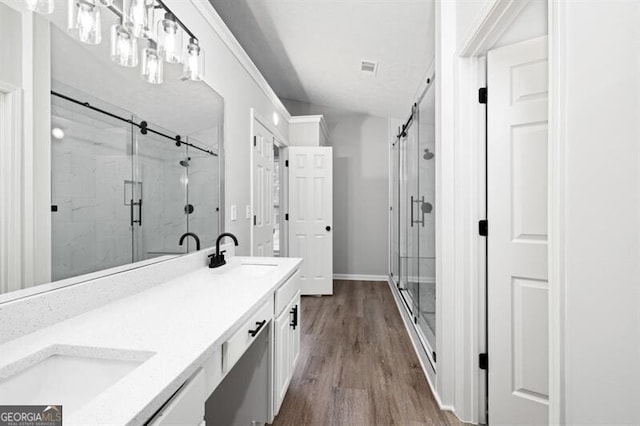 bathroom featuring hardwood / wood-style floors, vanity, and a shower with shower door