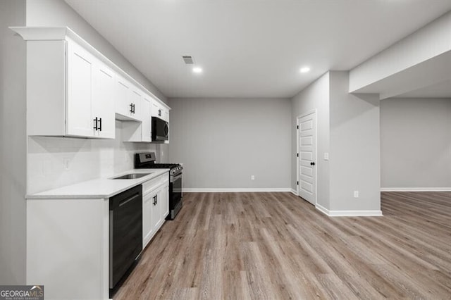 kitchen featuring white cabinets, stainless steel gas range, sink, light hardwood / wood-style flooring, and dishwasher