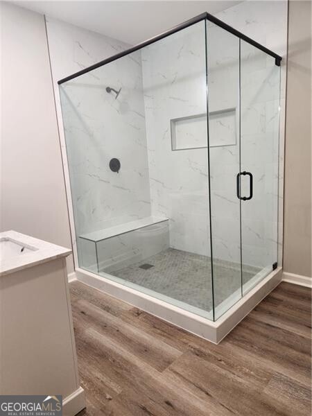 bathroom featuring hardwood / wood-style floors, vanity, and walk in shower