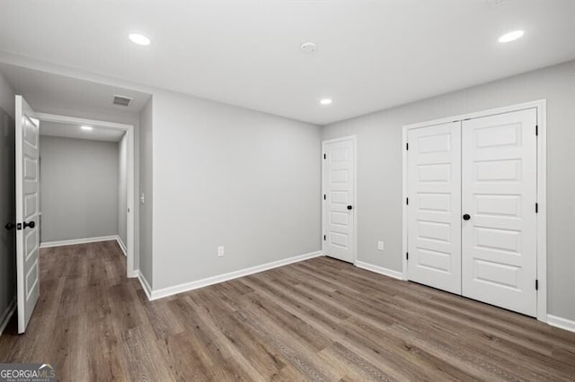 unfurnished bedroom with wood-type flooring and a closet