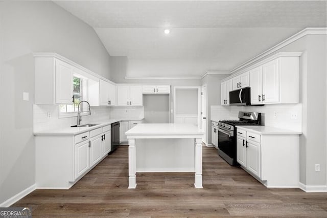 kitchen featuring white cabinets, a center island, and gas stove