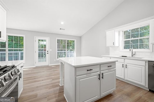 kitchen featuring appliances with stainless steel finishes, tasteful backsplash, white cabinetry, and sink