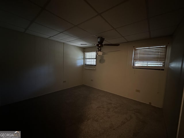 carpeted empty room featuring ceiling fan and a drop ceiling