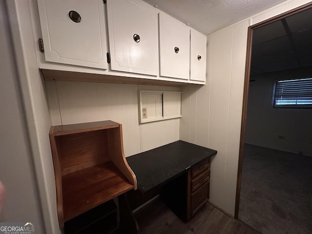 unfurnished office with dark wood-type flooring and a textured ceiling