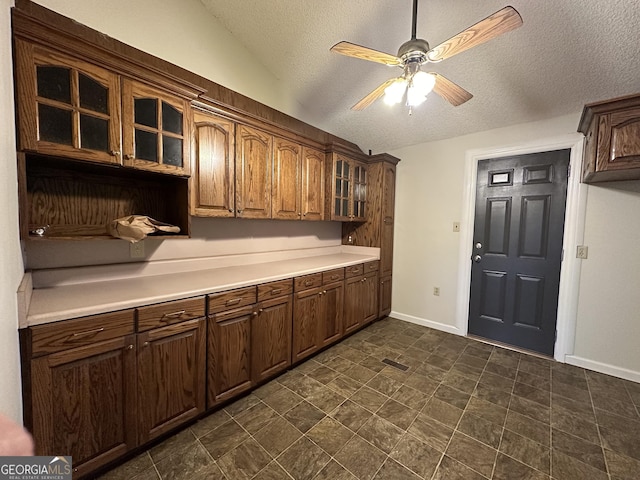 kitchen featuring a textured ceiling, ceiling fan, and lofted ceiling