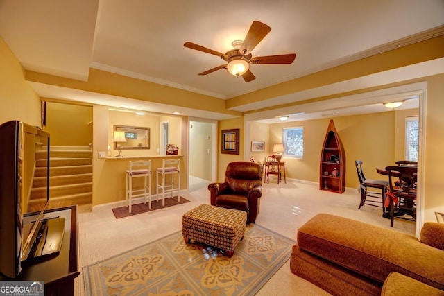 carpeted living room with ceiling fan and ornamental molding