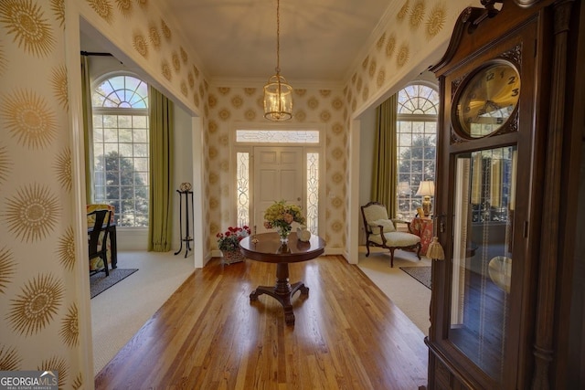 entryway featuring ornamental molding and light wood-type flooring