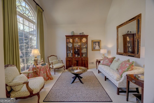 sitting room featuring carpet and lofted ceiling