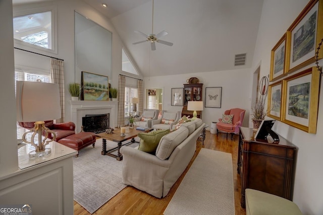 living room featuring light hardwood / wood-style floors, high vaulted ceiling, and ceiling fan