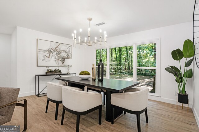 dining area featuring light hardwood / wood-style floors and an inviting chandelier