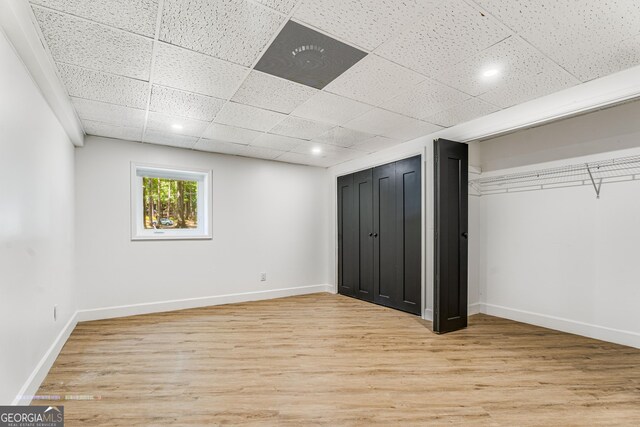 unfurnished bedroom with a paneled ceiling and light hardwood / wood-style flooring