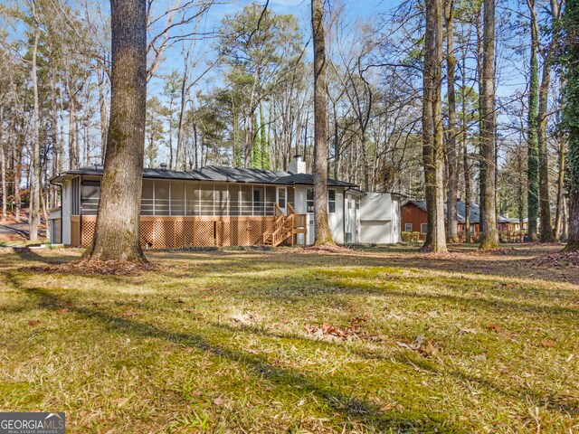 view of front of home with a sunroom and a front yard