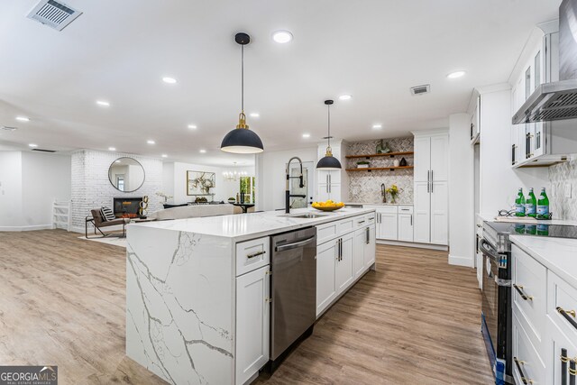 kitchen with dishwasher, a center island with sink, white cabinets, electric range, and decorative light fixtures