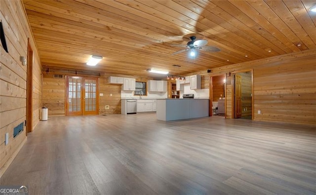 unfurnished living room with wood-type flooring, ceiling fan, wooden ceiling, and wood walls