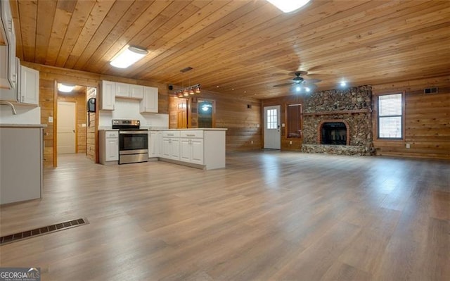 kitchen featuring electric range, hanging light fixtures, a fireplace, white cabinets, and wood ceiling