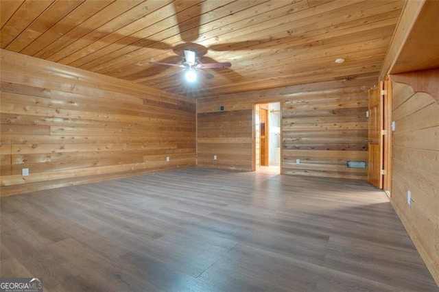 empty room featuring ceiling fan, hardwood / wood-style floors, wood ceiling, and wood walls