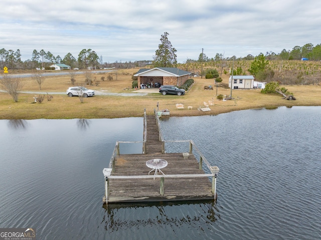 dock area with a lawn and a water view