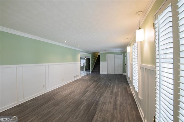 spare room featuring dark hardwood / wood-style floors and crown molding