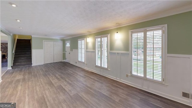 unfurnished living room featuring hardwood / wood-style flooring and ornamental molding