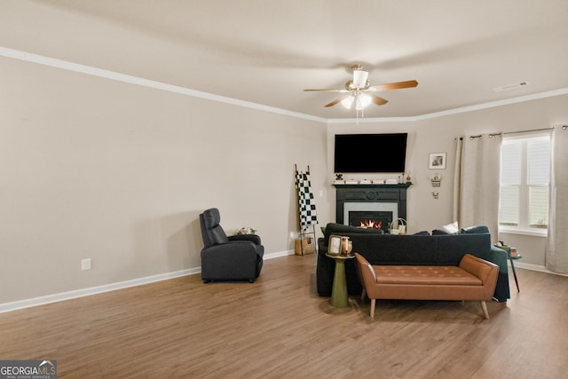 living room with crown molding, ceiling fan, and wood-type flooring