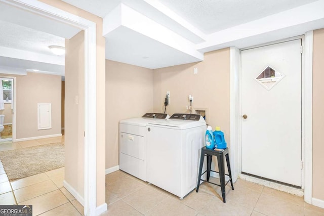 laundry room with washer and clothes dryer, light tile patterned floors, and a textured ceiling