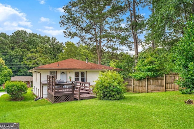 back of house with a wooden deck and a yard