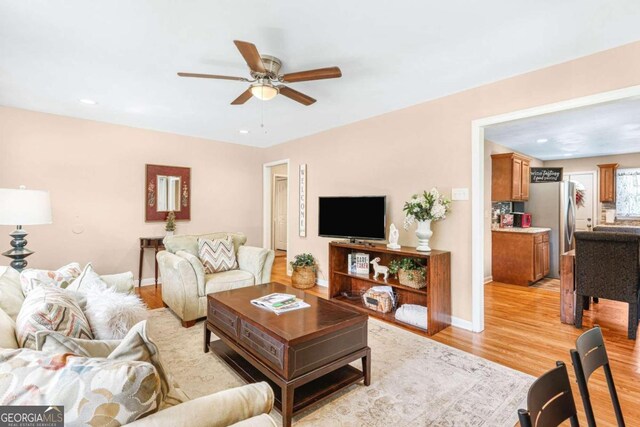 living room featuring ceiling fan and light wood-type flooring