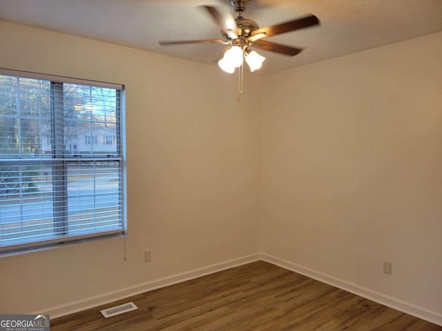 unfurnished room featuring dark hardwood / wood-style floors, plenty of natural light, and ceiling fan