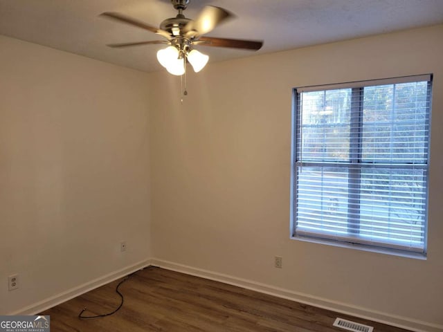 spare room with dark hardwood / wood-style floors and ceiling fan