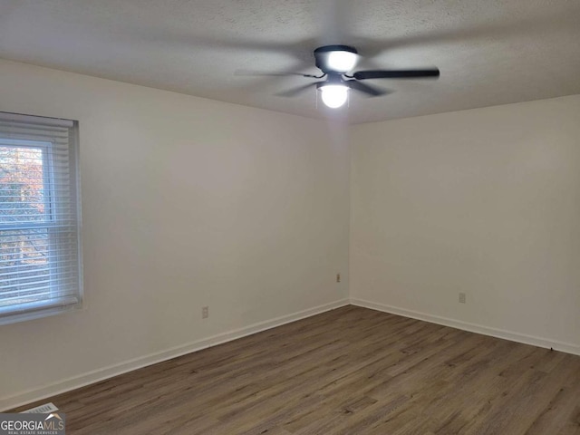 empty room featuring a textured ceiling, dark hardwood / wood-style flooring, and ceiling fan