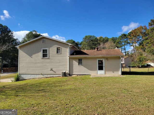 back of property featuring a yard and central air condition unit