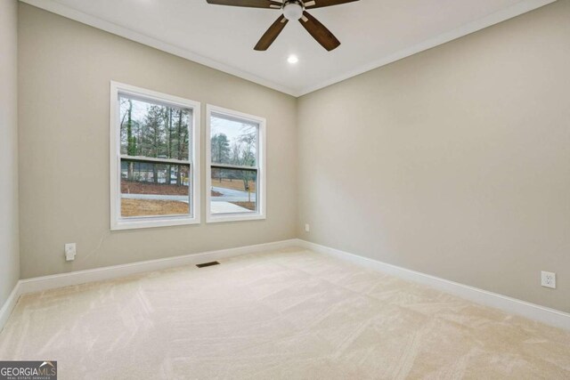 carpeted empty room featuring ceiling fan and crown molding