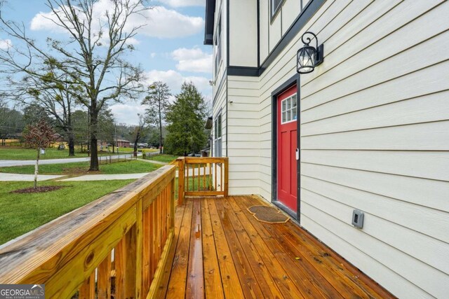 wooden terrace featuring a yard