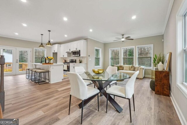 dining room featuring a wealth of natural light, ceiling fan, french doors, and light hardwood / wood-style floors