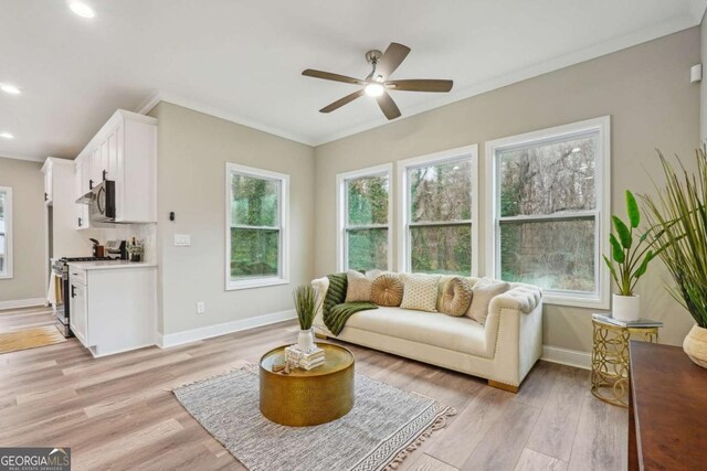 living room with light wood-type flooring, ceiling fan, and ornamental molding