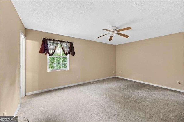 spare room featuring ceiling fan, carpet floors, and a textured ceiling