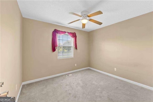 carpeted empty room featuring ceiling fan and a textured ceiling